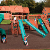 Children playing on a large wooden playground with multiple slides and climbing structures.