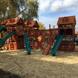 Wooden playground with slides and sand area on a sunny day