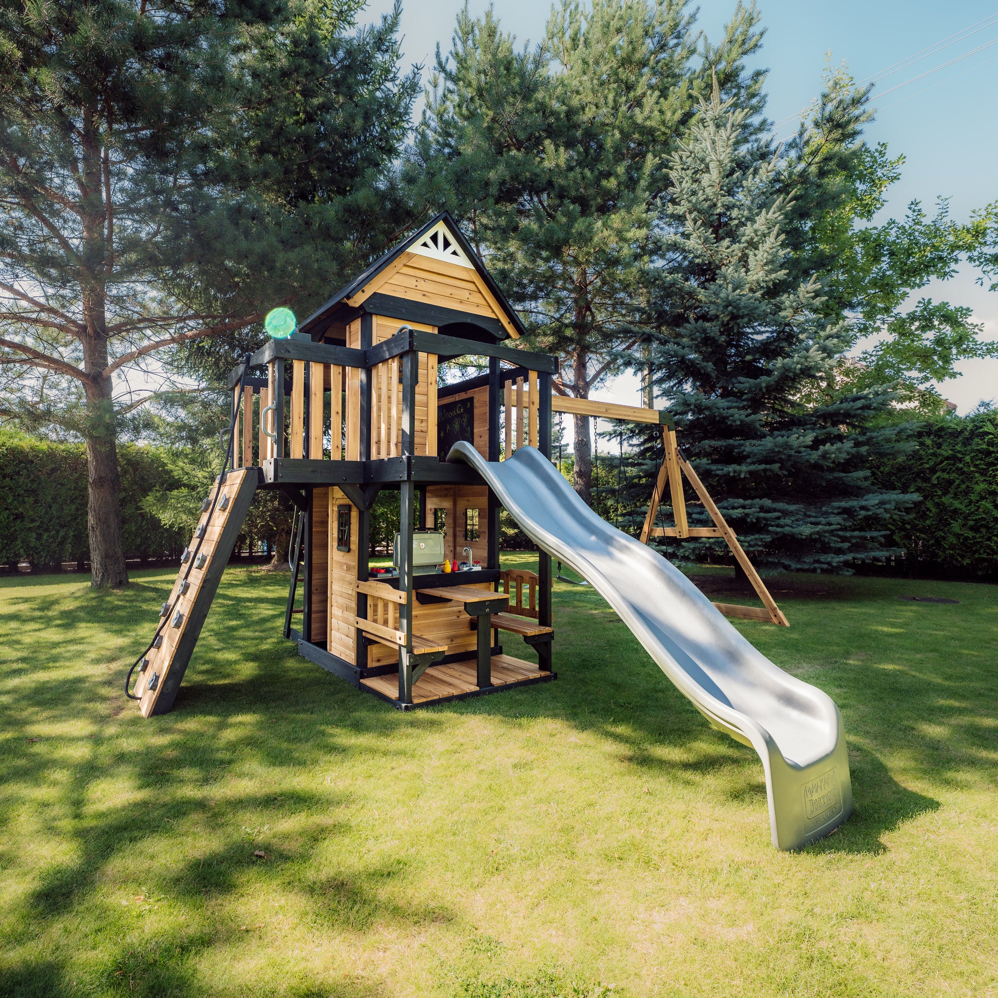 Canyon Creek cedar swing set from the side with the 3 m grey wave slide on a lawn